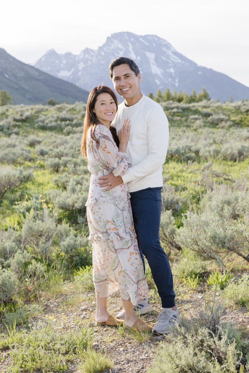  Man and woman hold each other and look at camera during an adventurous couple sessions in Jackson Hole. 