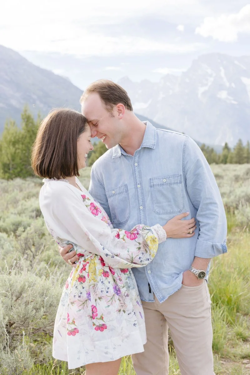 Man and woman lean into each other during an engagement shoot in the Tetons. 