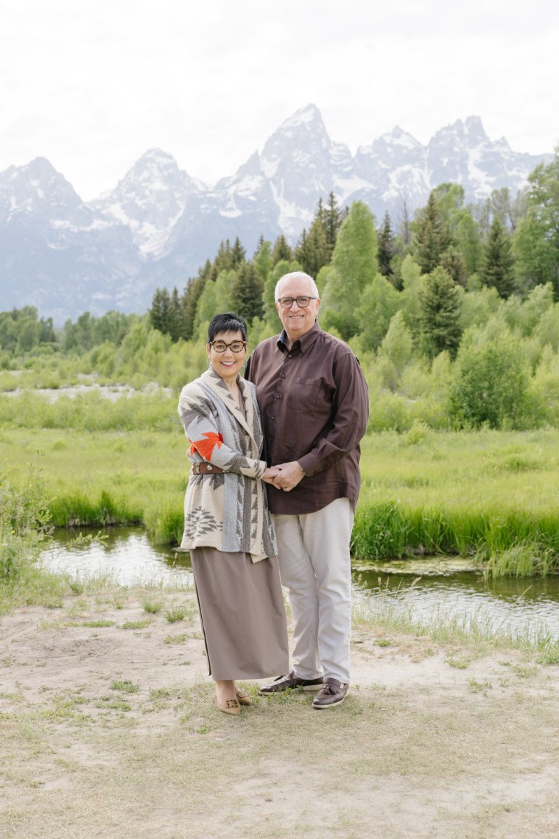  Couple smiling together with the Tetons in the background photographed by a Jackson WY photographer 