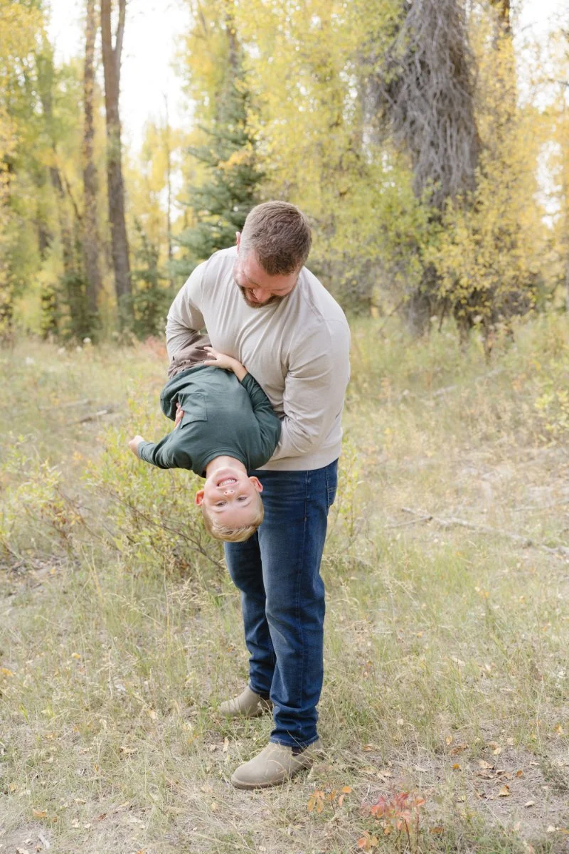  Father playing with his son in a wooded area during a Jackson WY photographer session 
