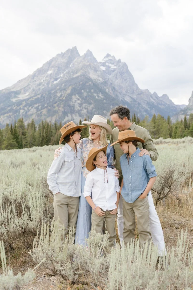  Family portrait during Grand Teton wildflowers season with children smiling beneath the Tetons 