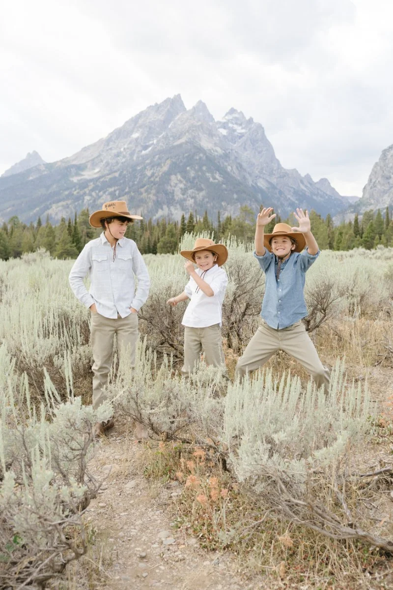  Kids playing in a Grand Teton wildflowers meadow during a family photography session 