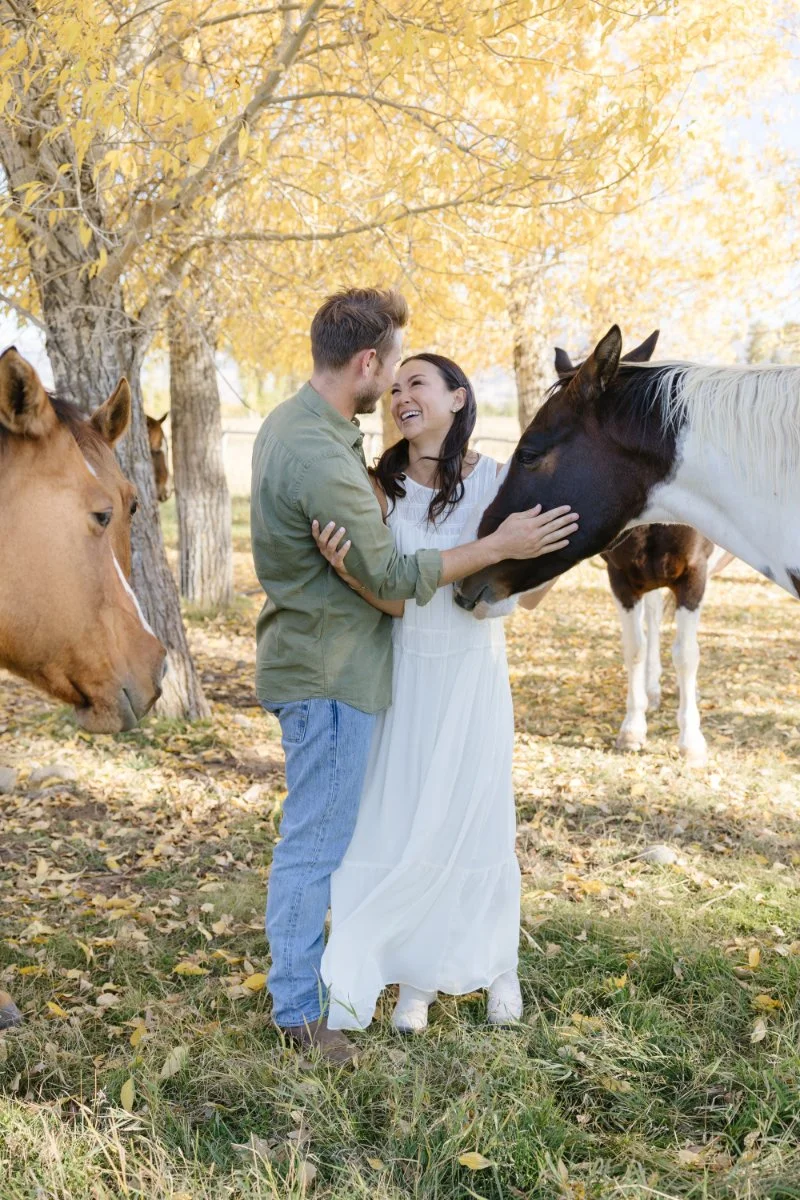  Couple with horses during a romantic Jackson Hole proposal session surrounded by beautiful fall scenery in Wyoming 