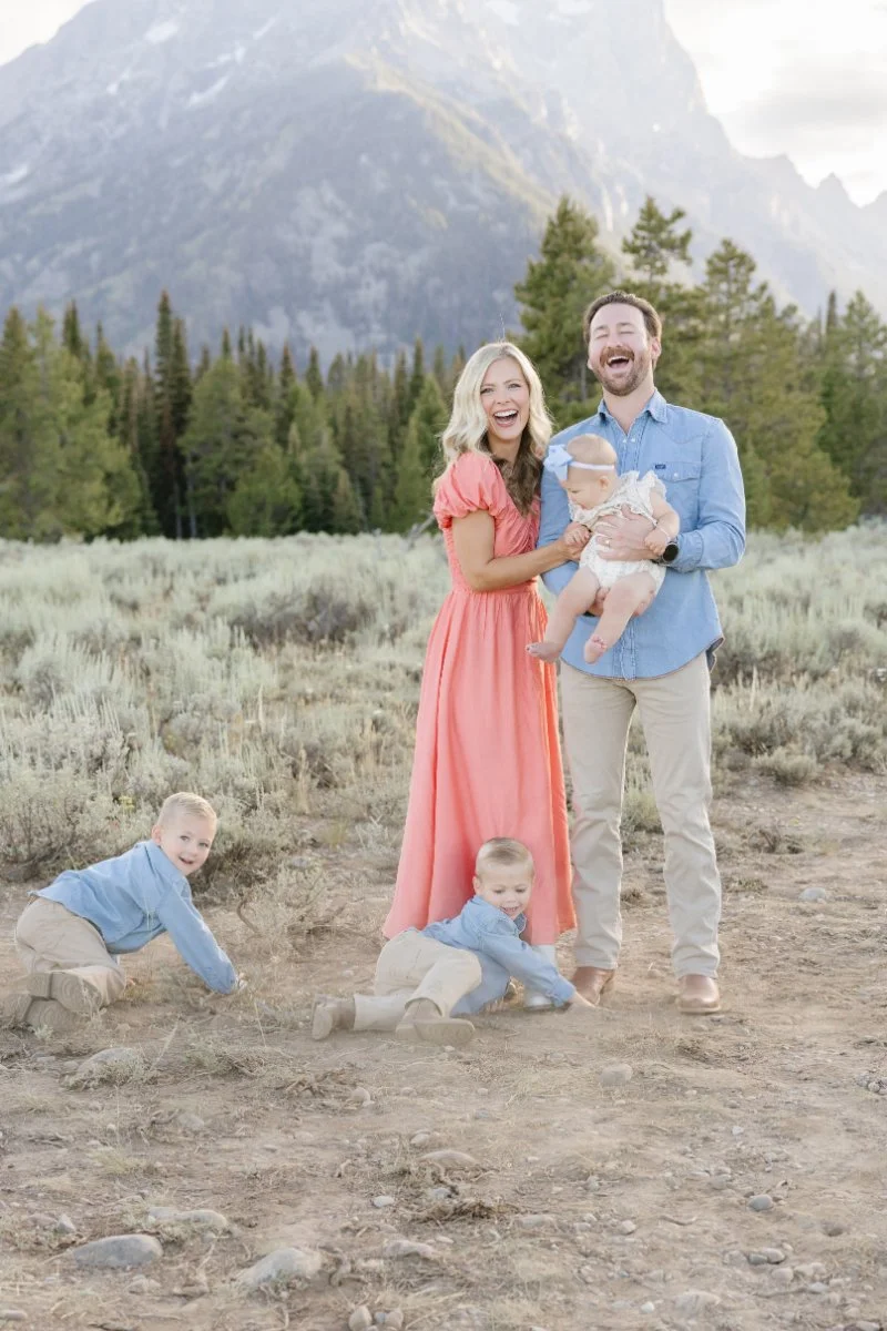  Family laughing together during a Grand Teton National Park session while traveling with babies and young children. 