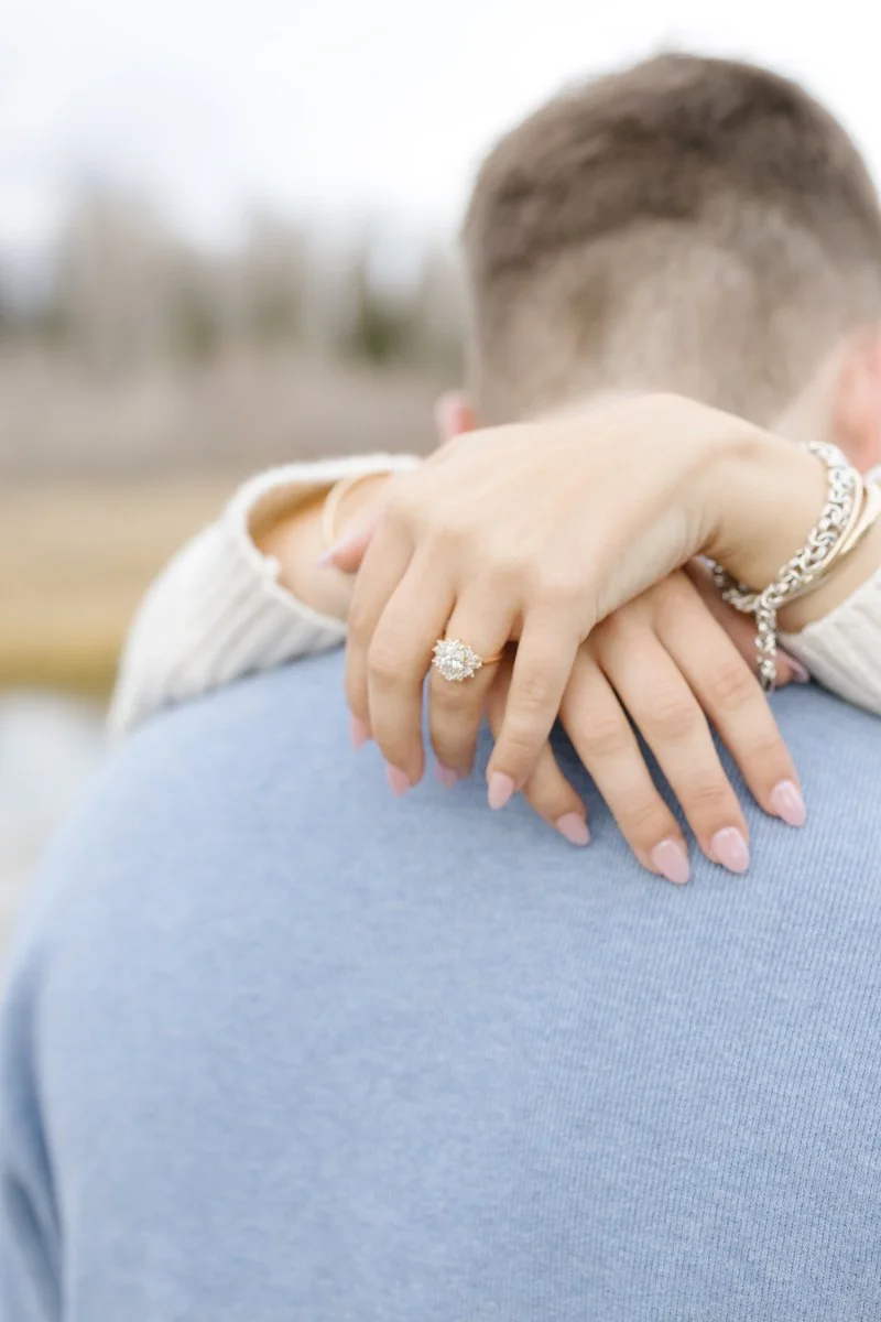  Close-up portrait of a couple after their Grand Teton proposal with the Teton mountain range behind them 