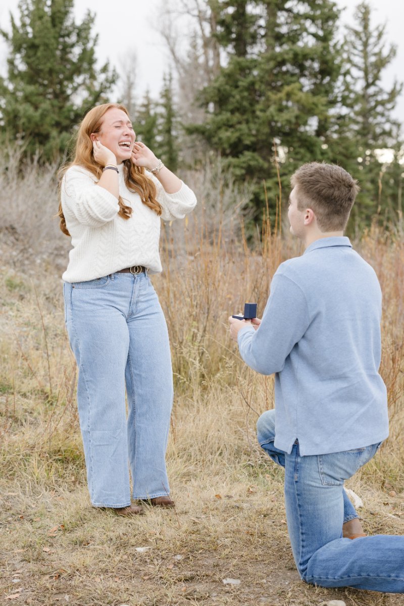  Joyful moment during a Grand Teton proposal as the couple celebrates their engagement 