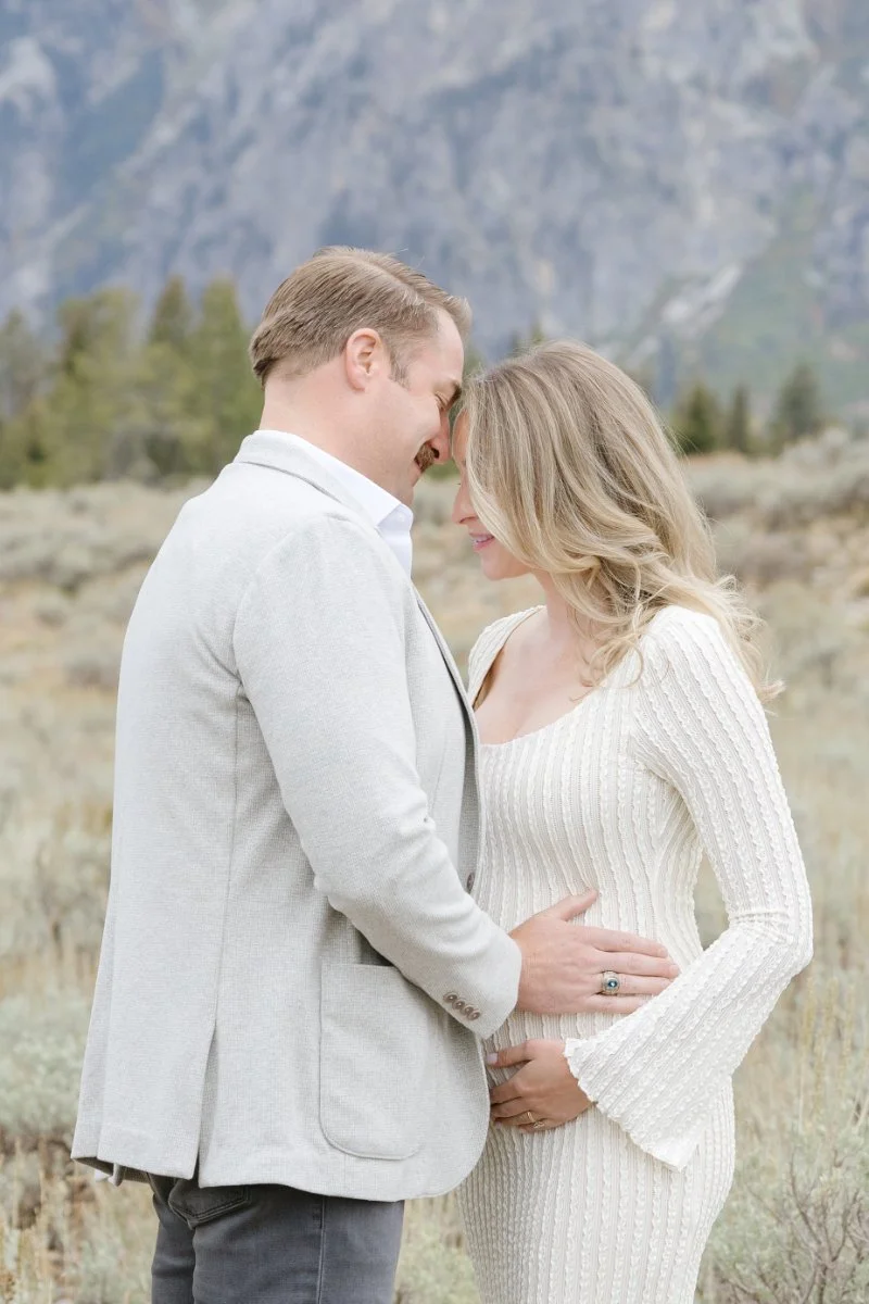  Expecting couple embracing during a Jackson Hole maternity session with mountain views 
