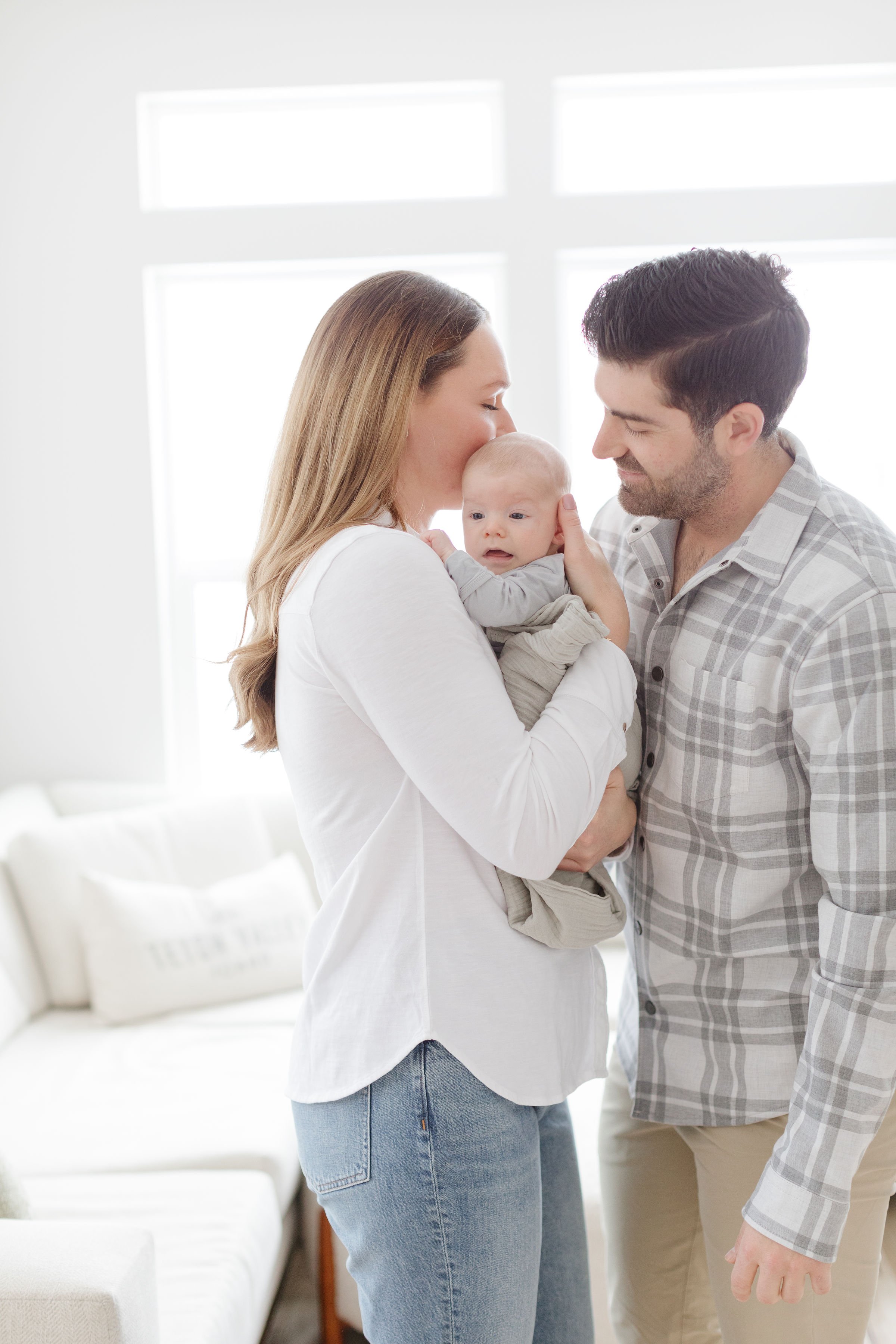 new parents standing with their baby- Jackson Hole family photographer