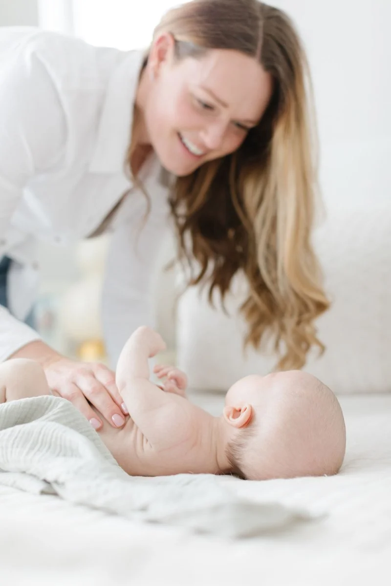 Mother swaddles baby during newborn session in Jackson Hole.