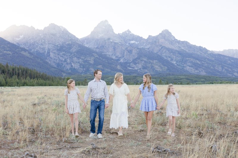 Family in the Grand Tetons with kids posing naturally for a family picture.