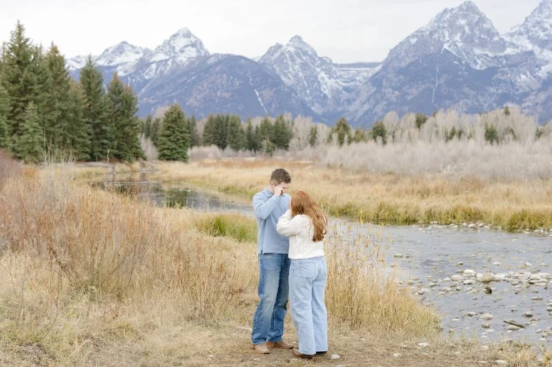 Newly engaged couple embracing during a Grand Teton proposal session with scenic mountain views