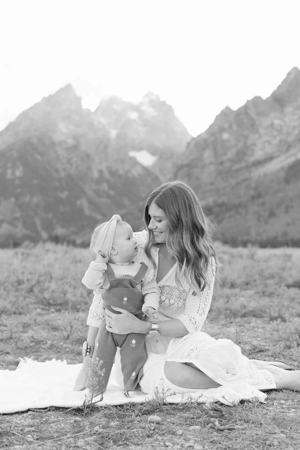 black and white photo of a mom and her baby with mountains in the back ground -  Ideas for Mother’s Day