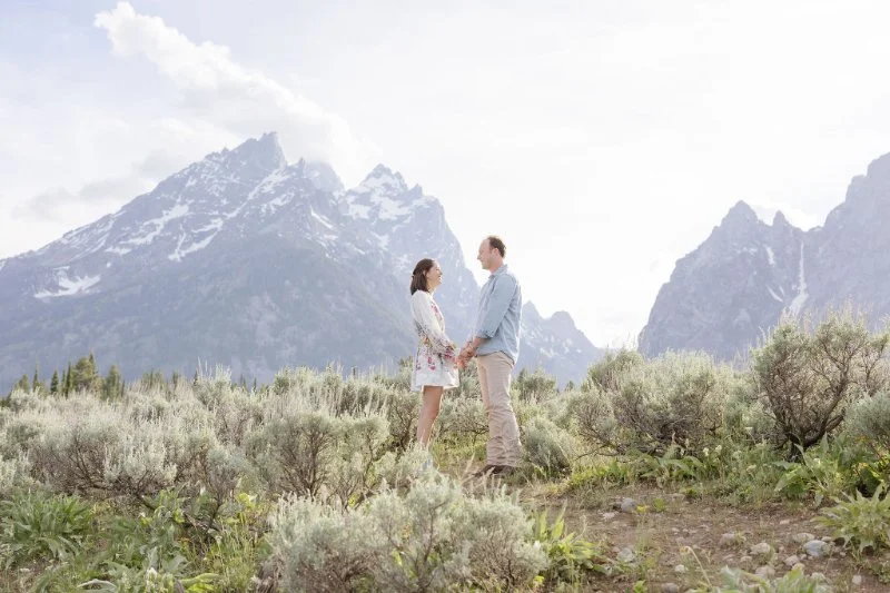 Couple standing together in Grand Teton National Park after a romantic Jackson Hole proposal with breathtaking mountain views in the background