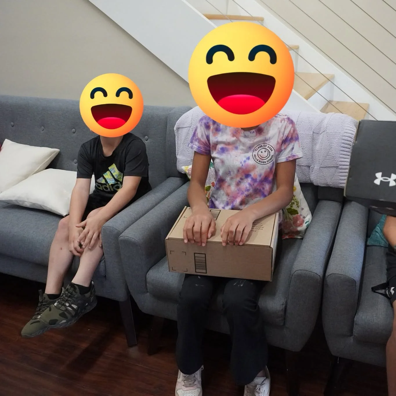 Children receiving a package of new shoes