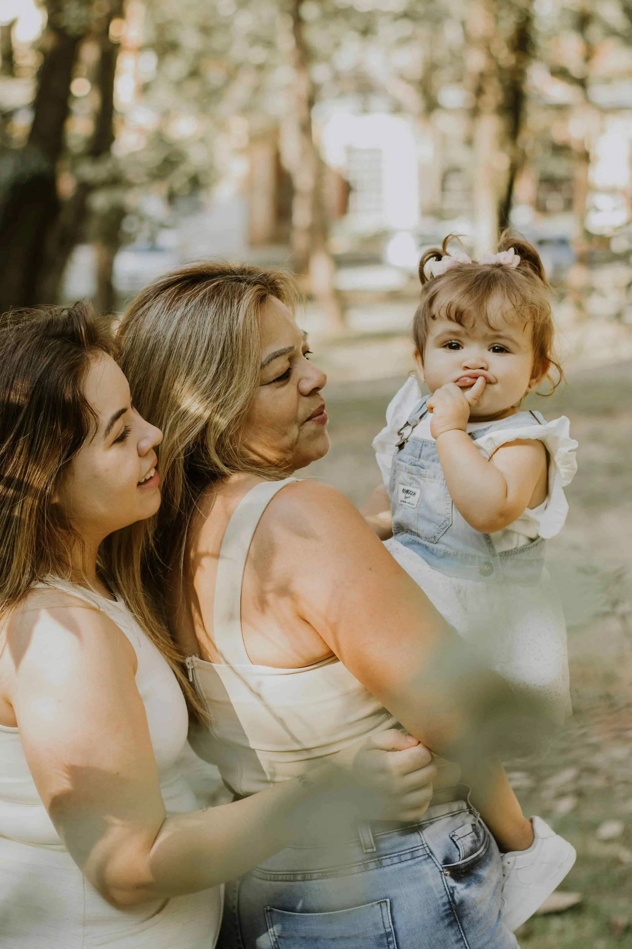 Three generations of women of color sharing a close moment outdoors, reflecting the complex family bonds and guilt often explored in therapy.