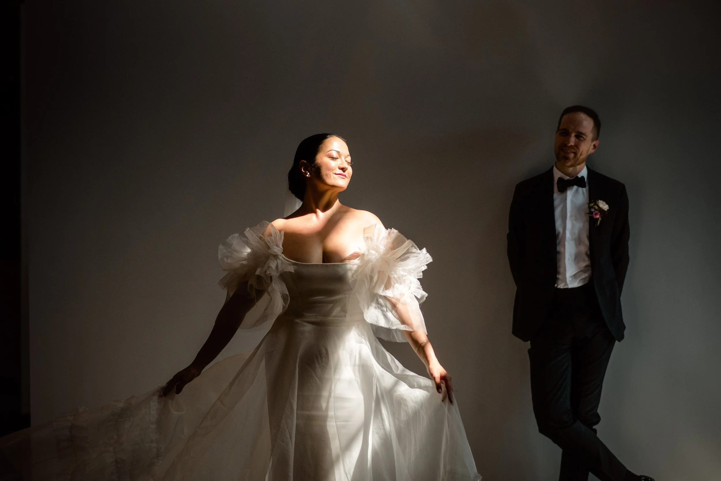 Seattle Wedding Photography - Bride flowing wedding gown glows in the spotlight while her loving groom gazes at her adoringly.jpg