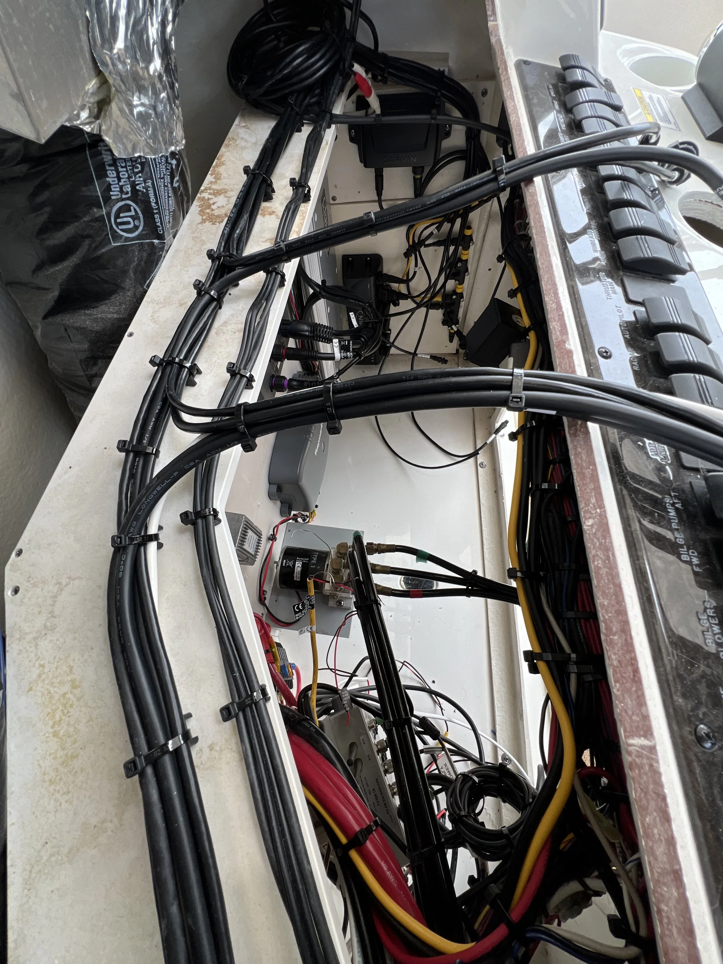 Interior view of a vehicle's garmin electrical wiring and components, including batteries, cables, and electronic modules.