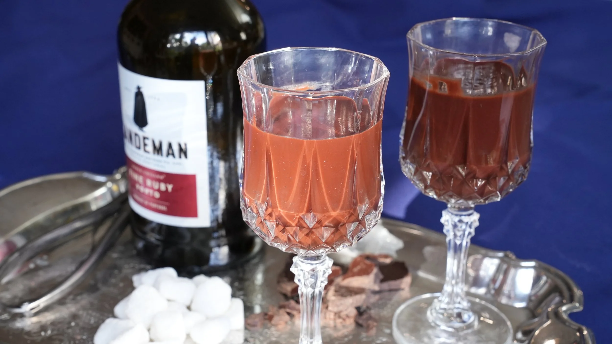 hot chocolate made with port in crystal glasses with sugar cubes port bottle on silver tray