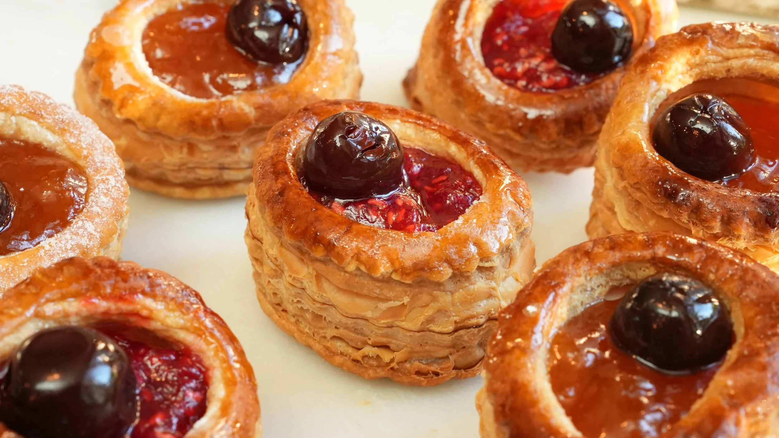 puff pastry rings filled with apricot and raspberry preserves topped with maraschino cherry