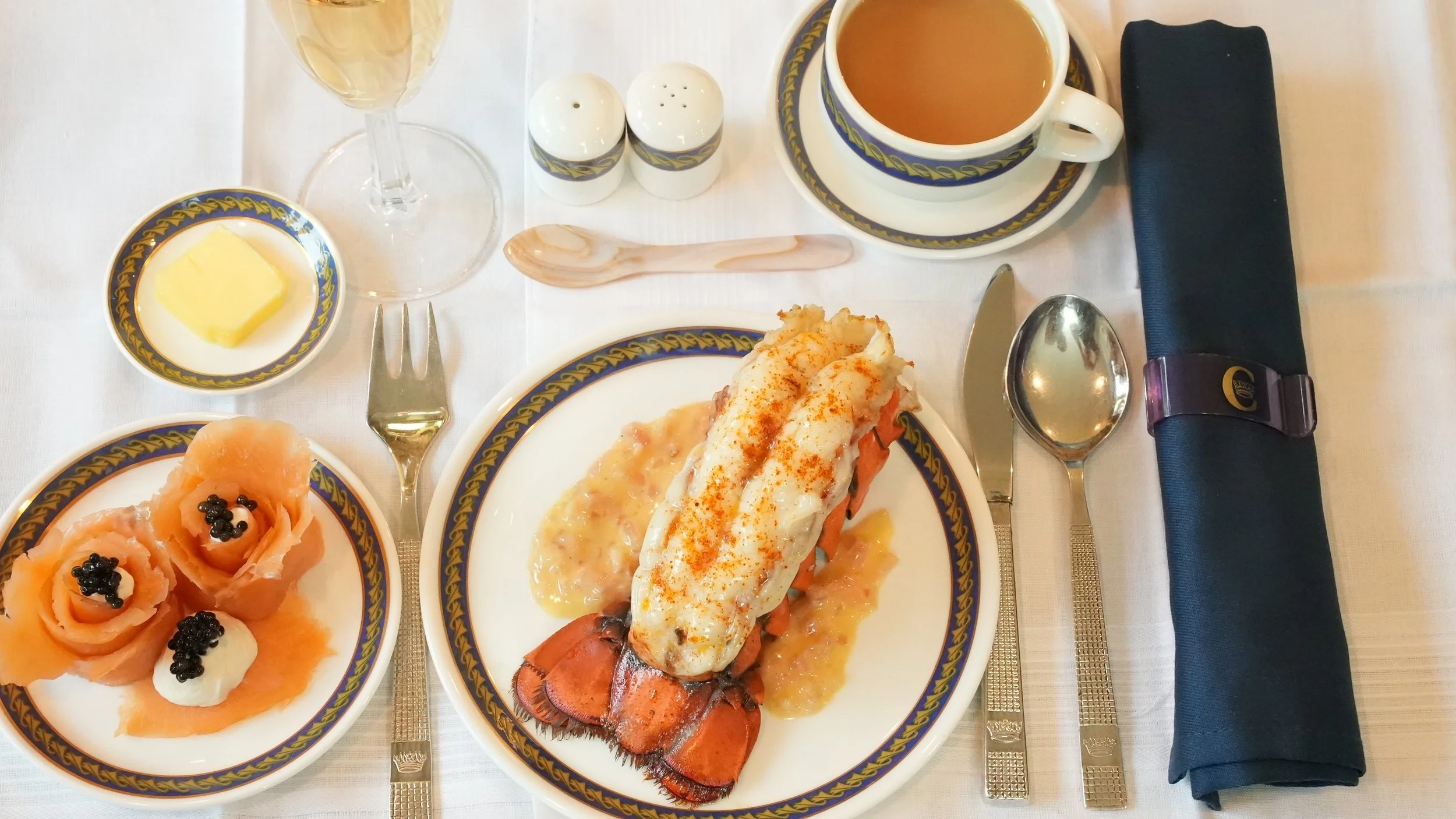lobster tail topped with creamy beurre blanc with smoked salmon roses garnished with creme fraiche and caviar with champagne, coffee, and butter