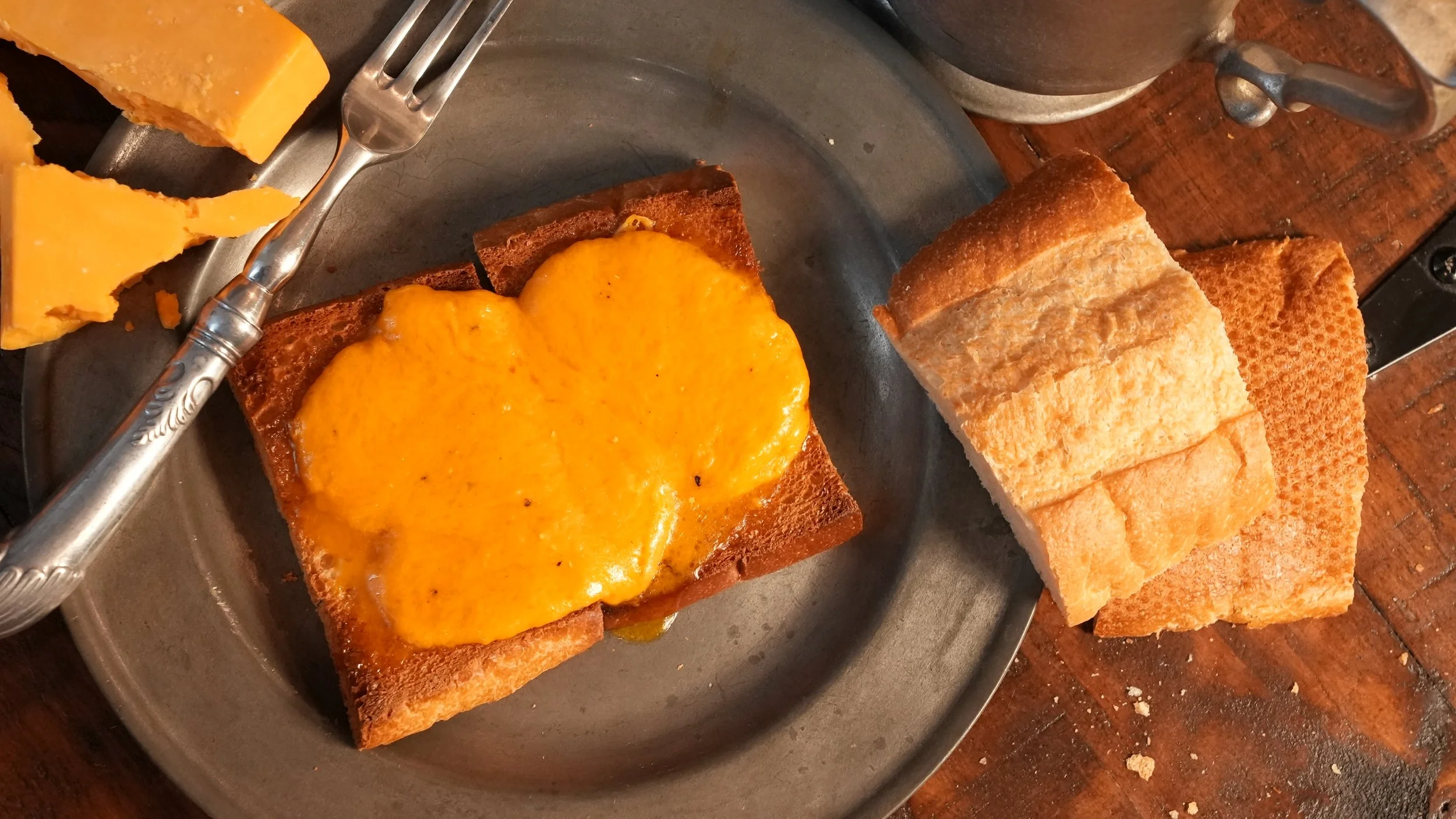 two slices buttered toast topped with smooth cheese sauce