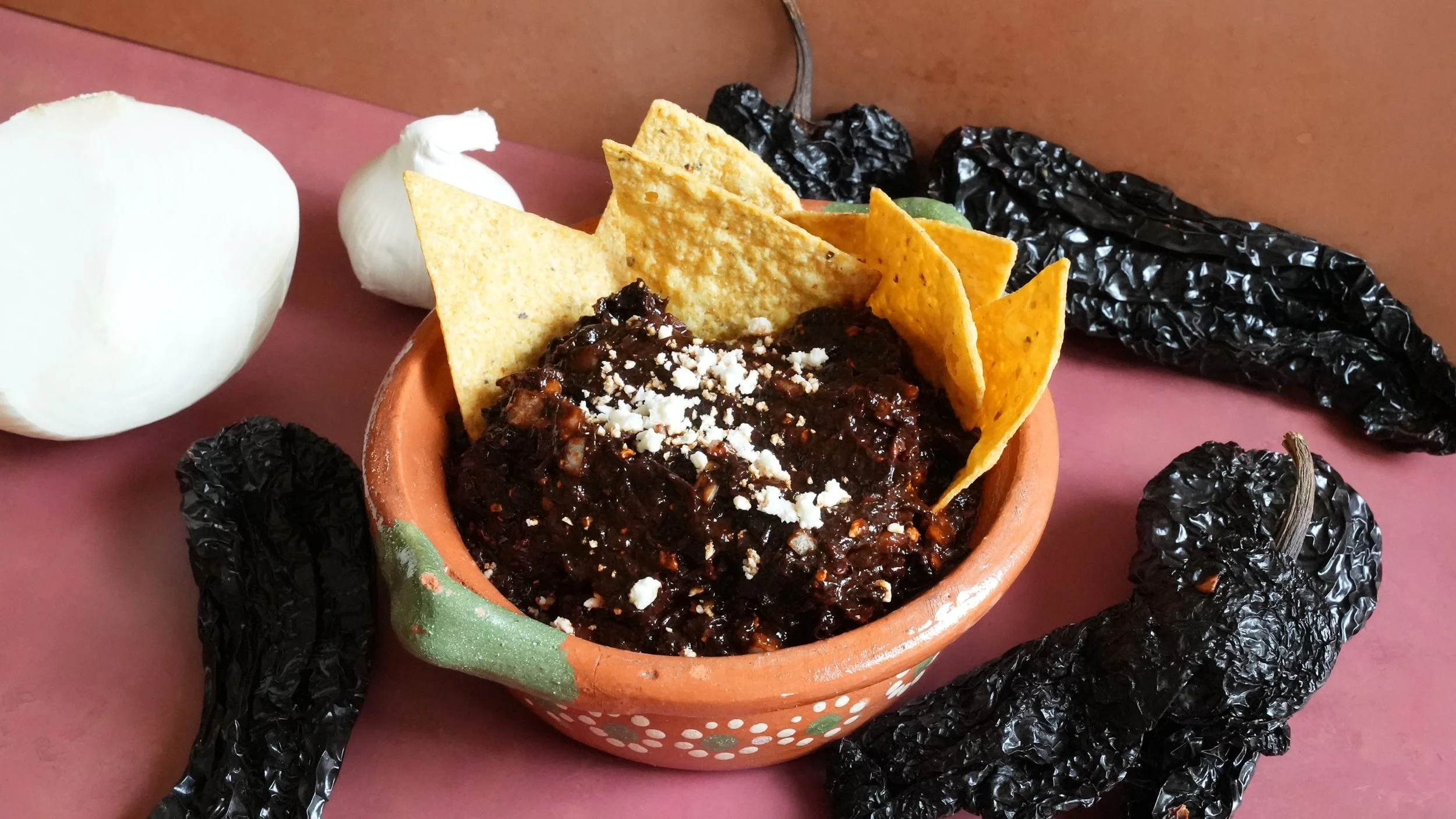 dark salsa made from dried chiles topped with crumbled cotija and tortilla chips