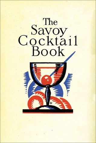cover of the 1930 Savoy Cocktail Book with an art deco cocktail glass with a marschino cherry