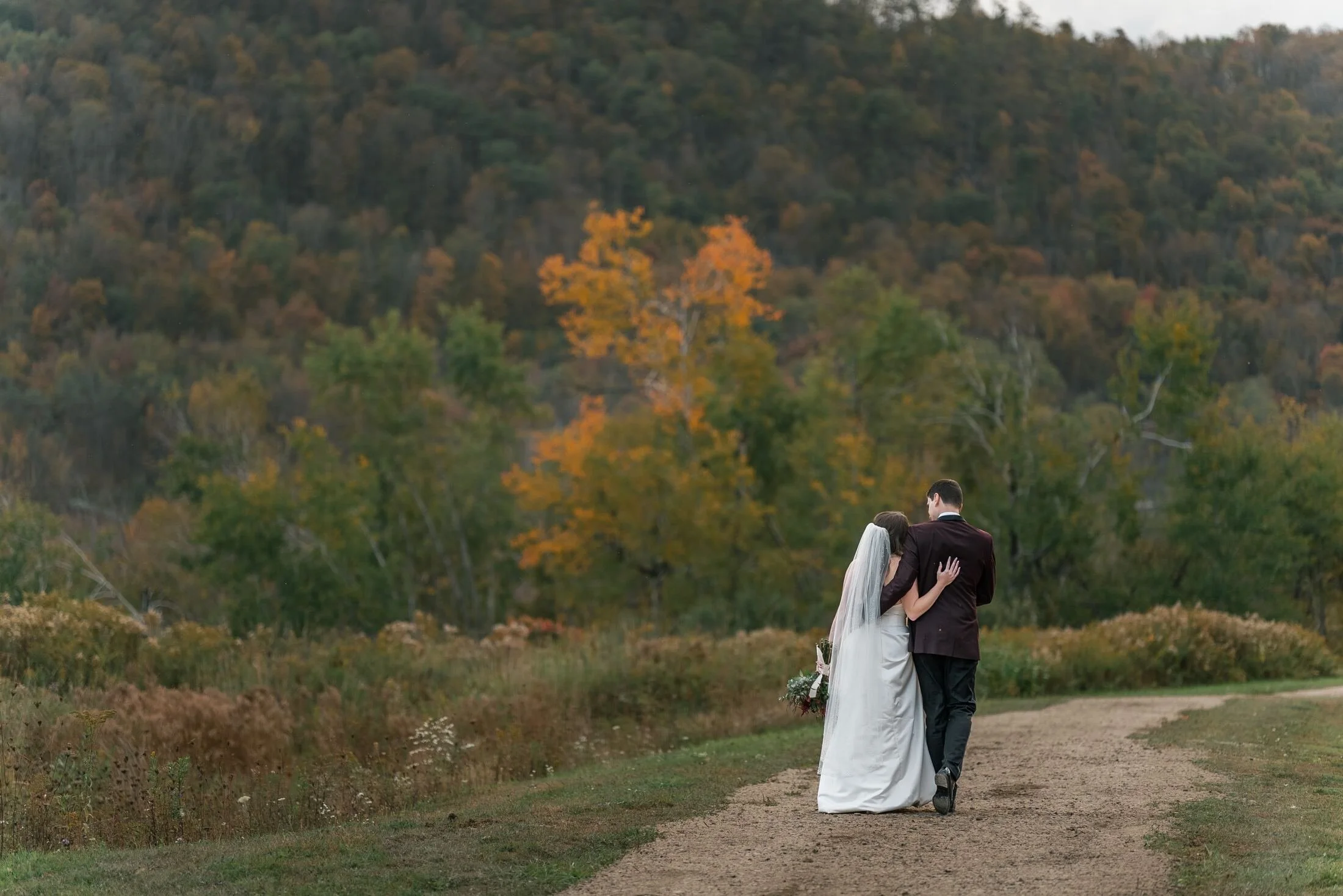 Newlyweds overlooking the mountain landscape at Greek Peak