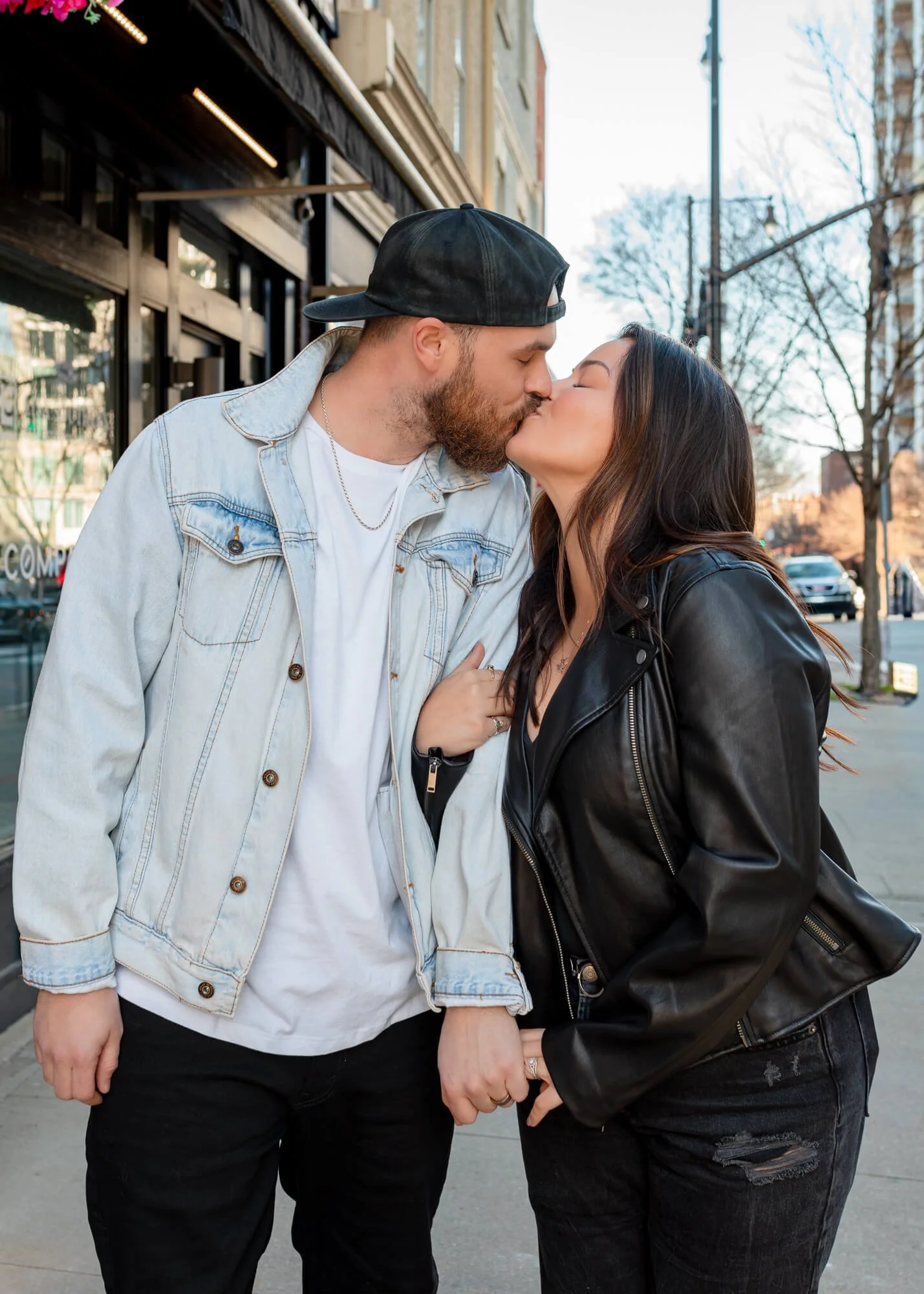 A couple kisses each other during a couples portrait session in downtown Raleigh, NC