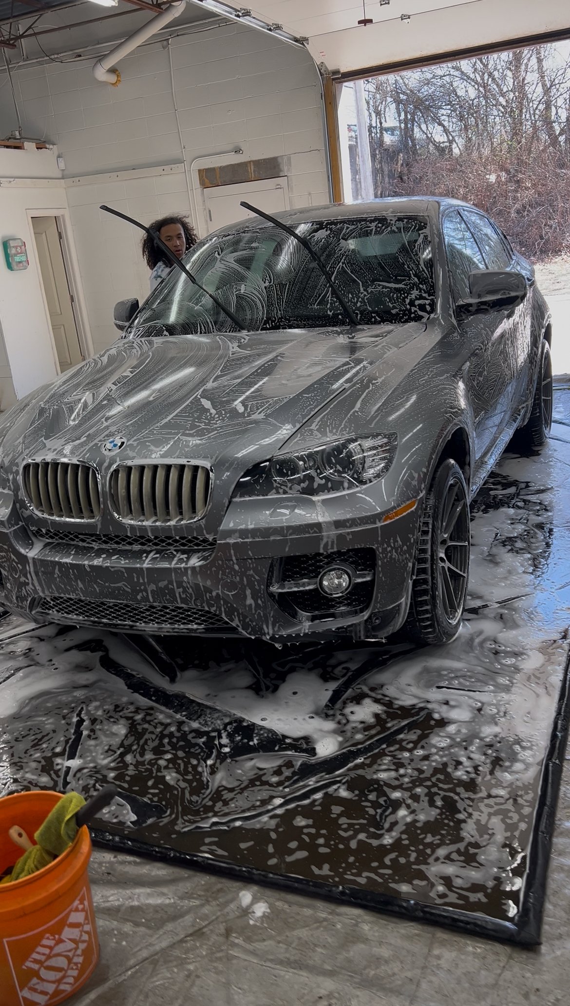 Detailer performing a hand wash and wax on a car at Empire Customs Car Detailing in Kansas City to enhance shine and protection.