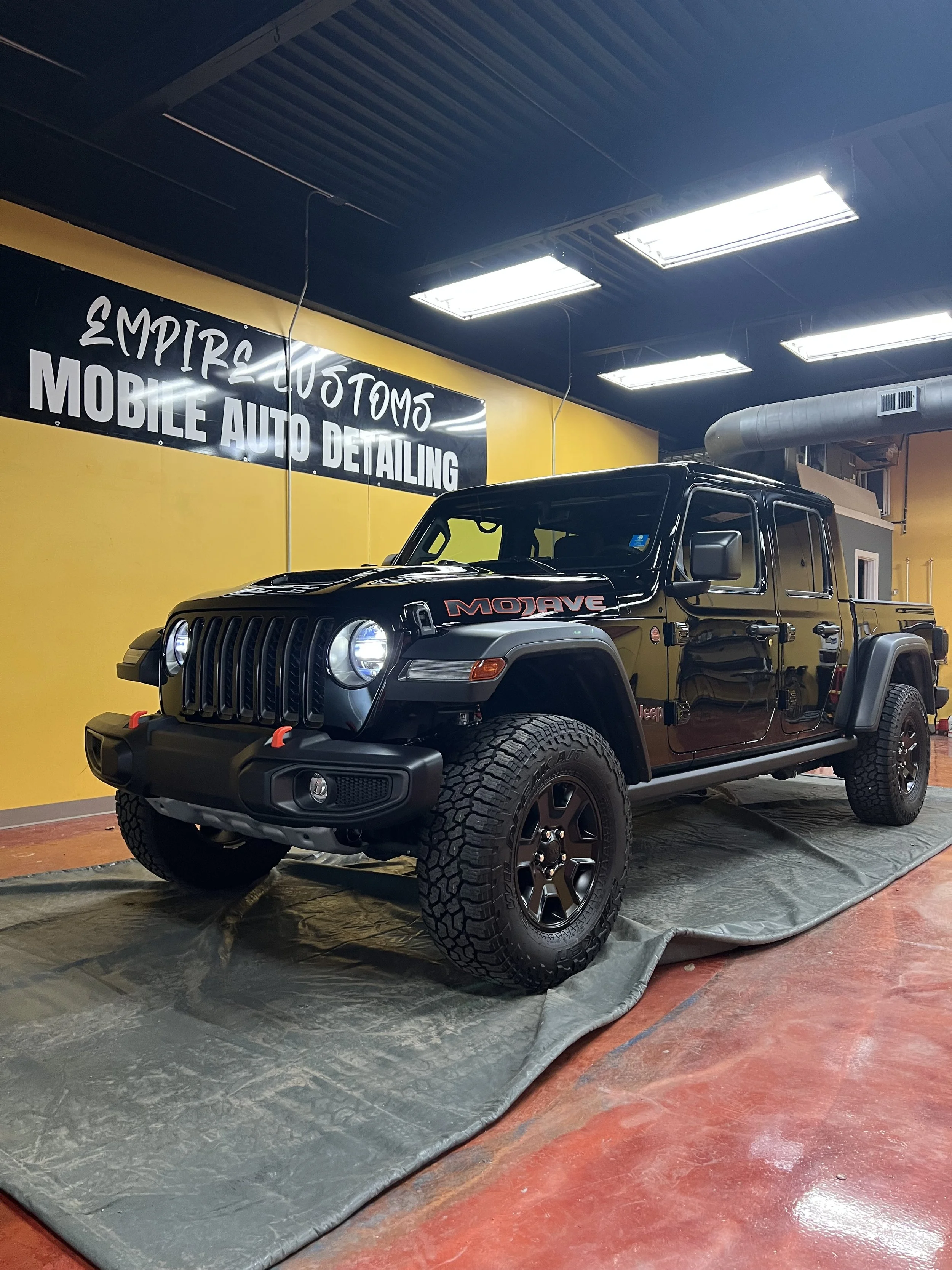 Detailer cleaning wheels and tires during a wash and wax package for a complete exterior refresh.
