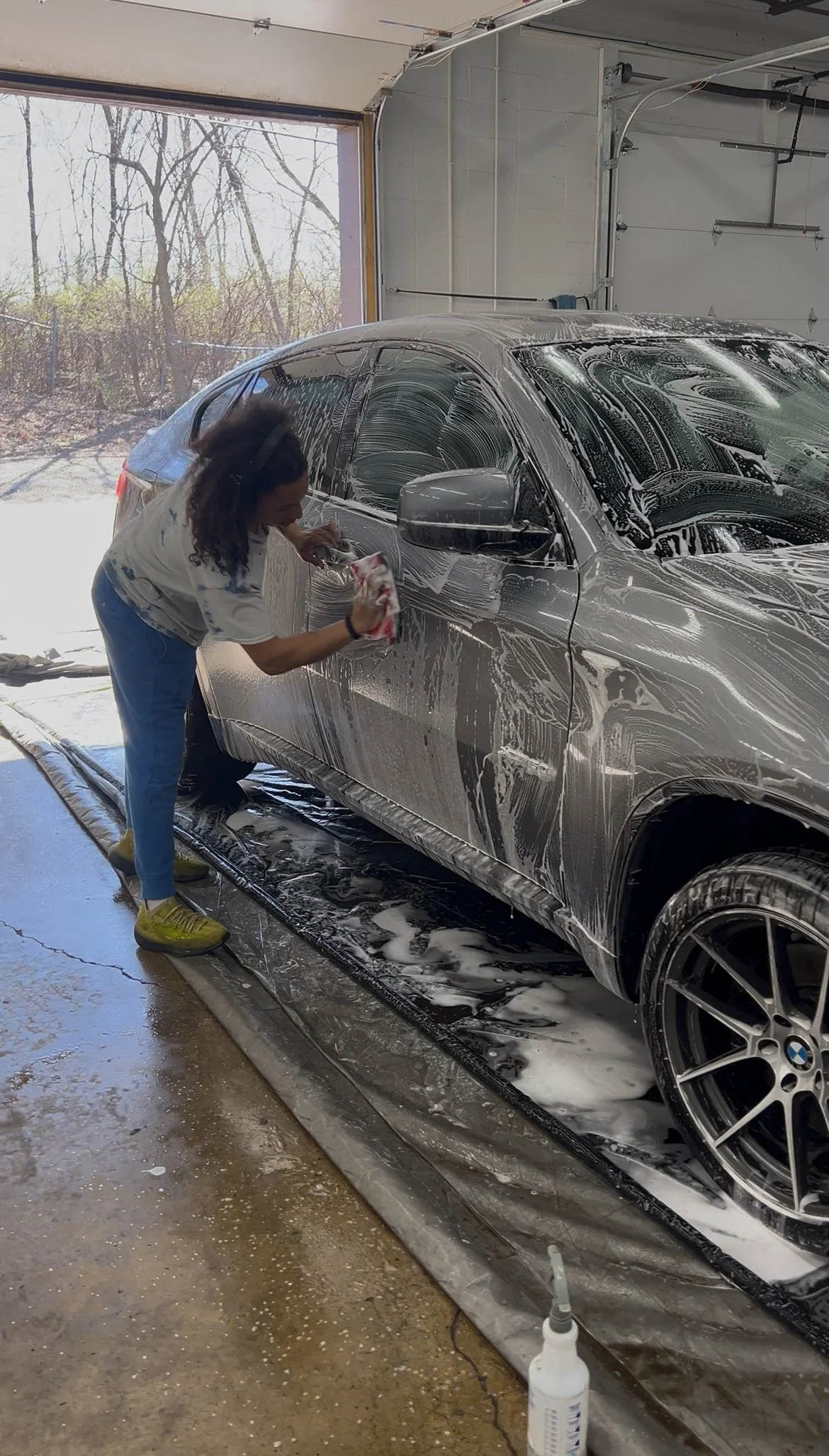 Foam cannon covering a vehicle during a wash and wax service to remove dirt before waxing.