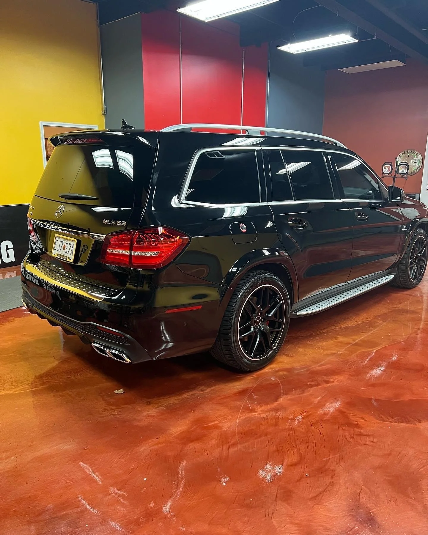 Detailer polishing a car door panel during a multi stage paint correction to enhance clarity and reflectivity.