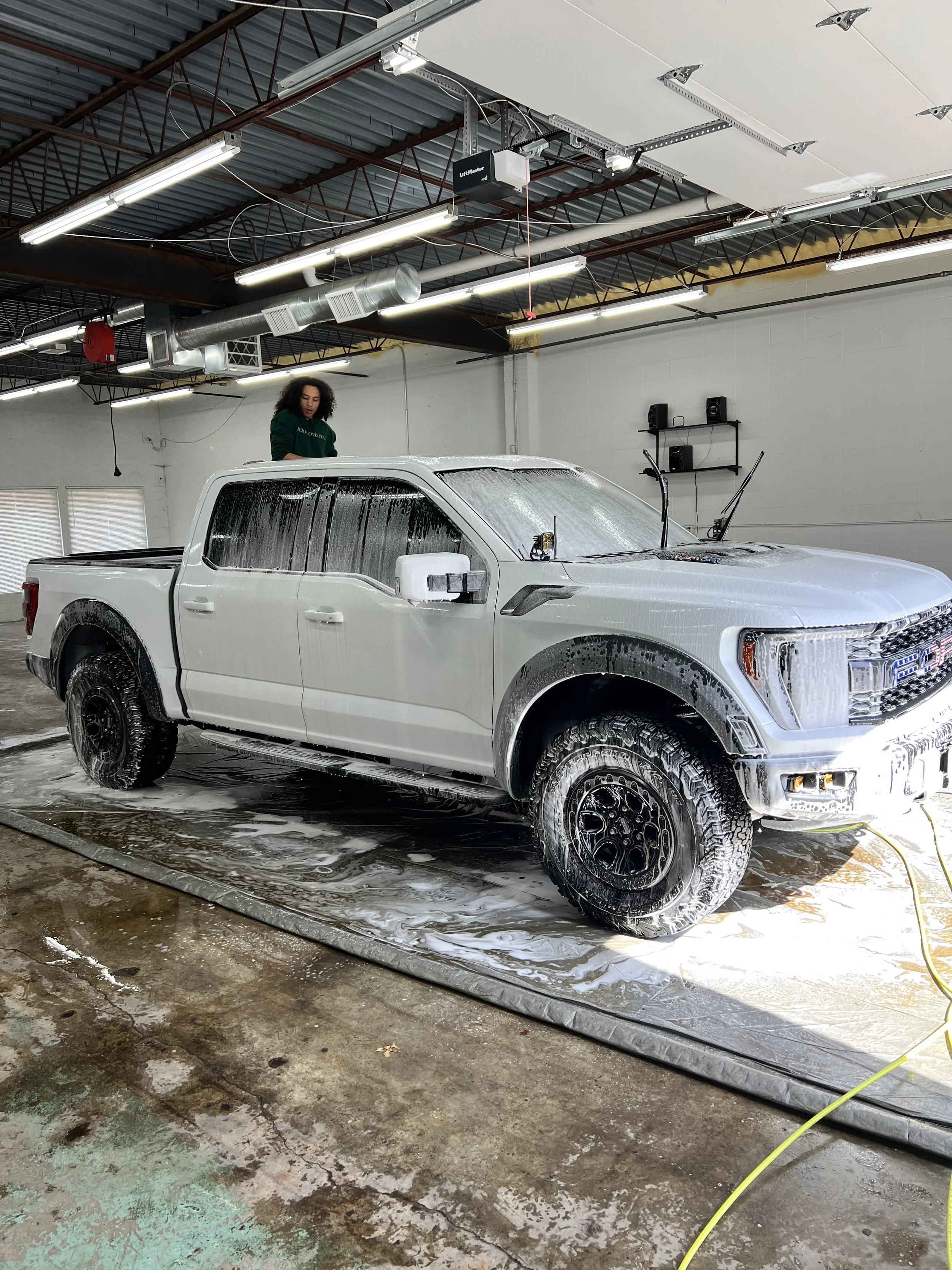 Detailer performing a hand wash and wax on a car at Empire Customs Car Detailing in Kansas City to enhance shine and protection.