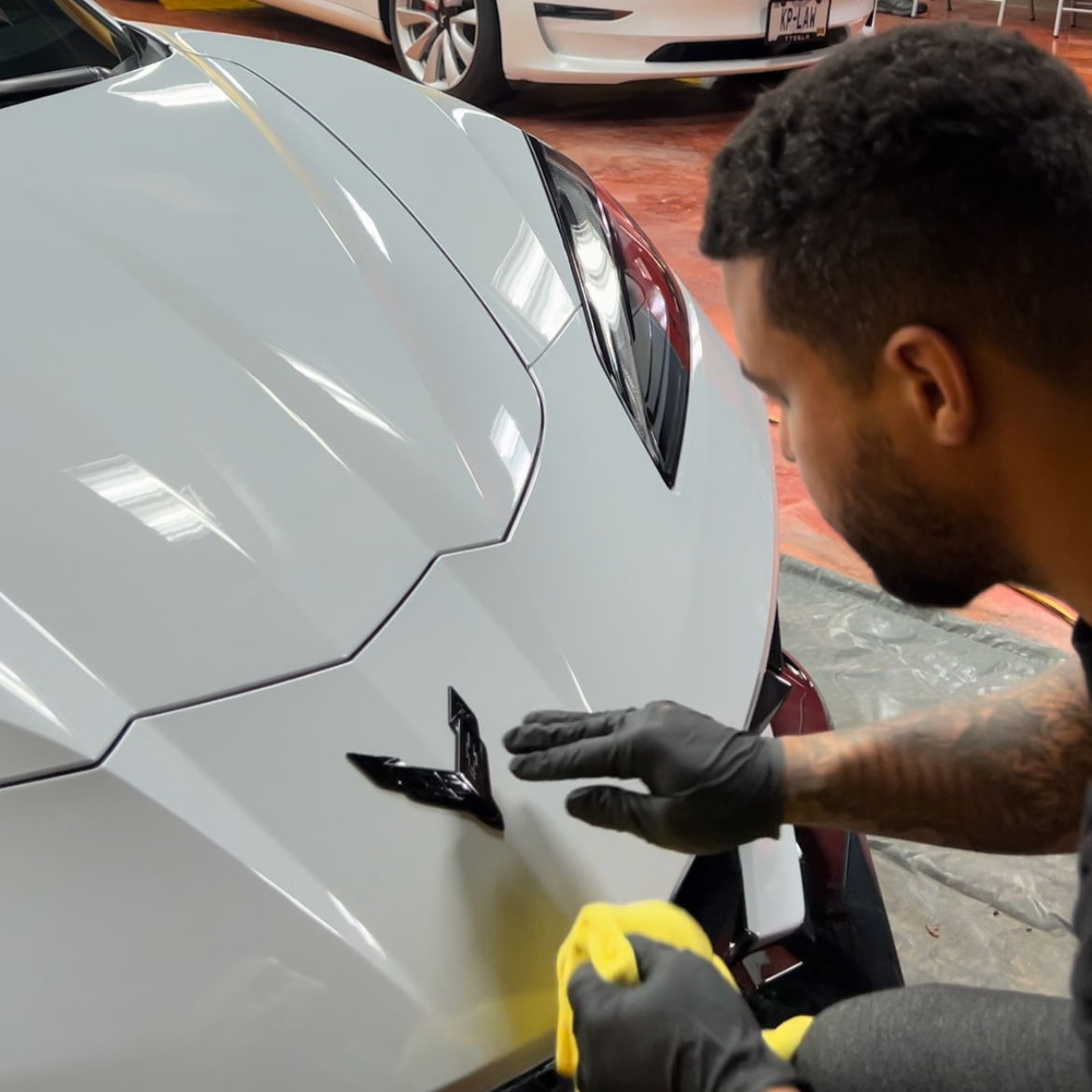 Professional PPF installation on a luxury vehicle at Empire Customs Car Detailing in Kansas City with a technician applying clear protective film to the hood.