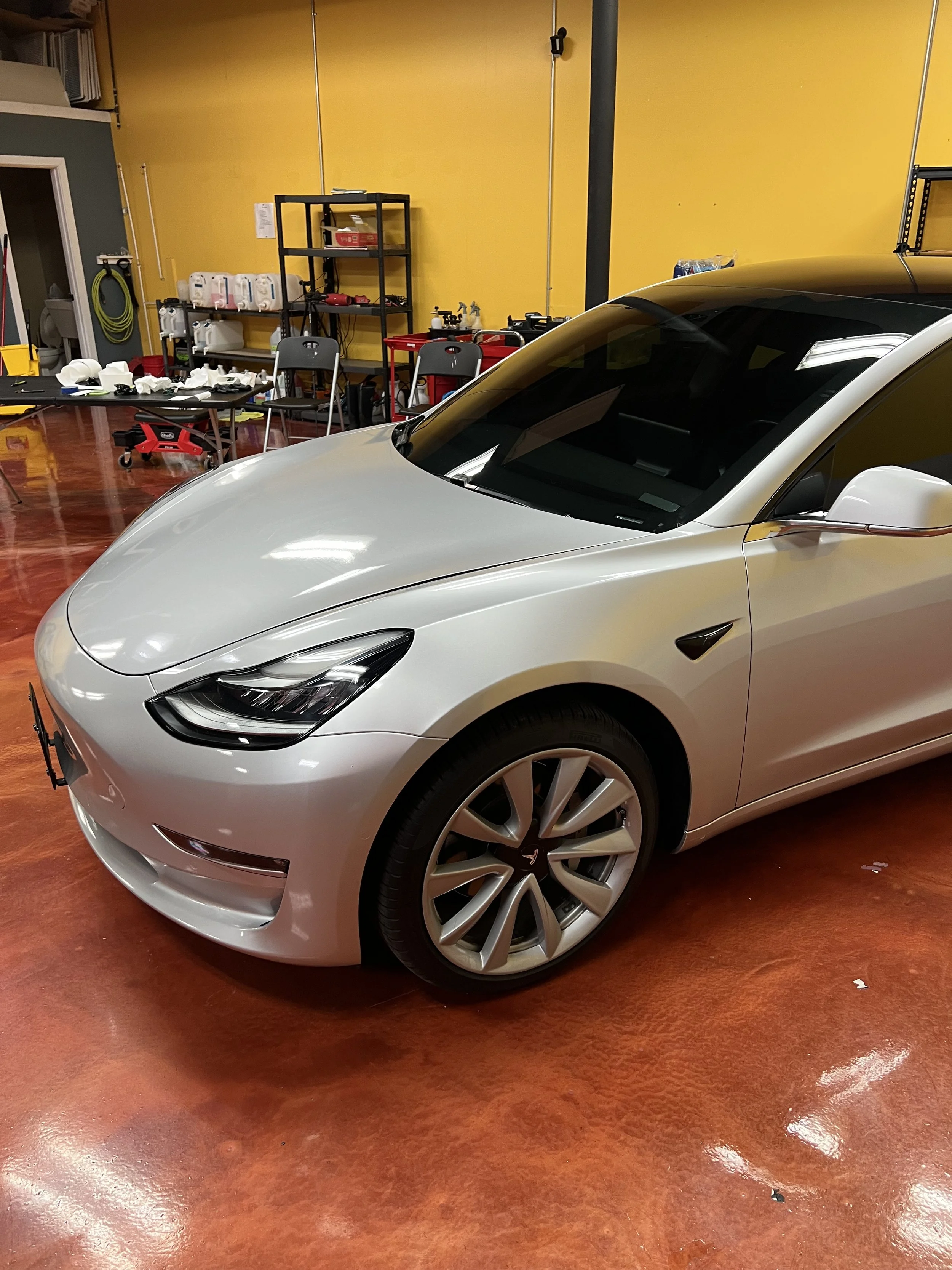 Clear bra PPF being installed on a Tesla to protect the paint from rock chips bugs and swirl marks.