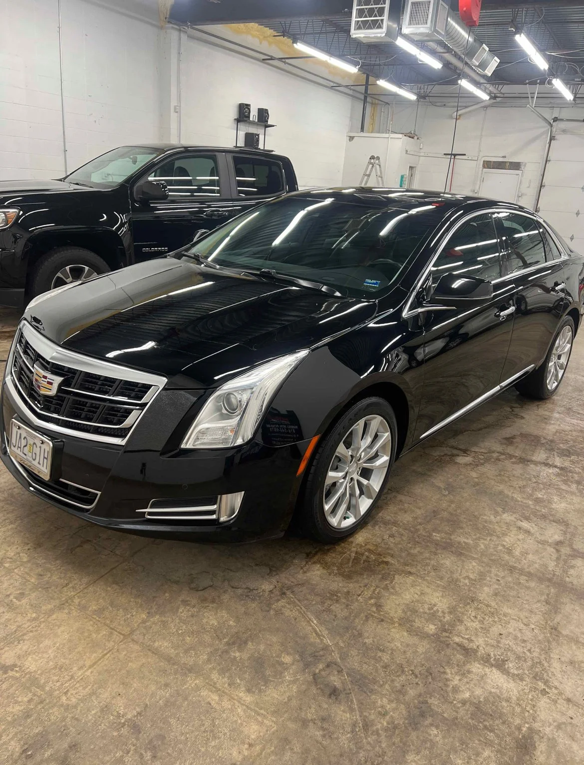 Close up of paint correction showing swirl mark removal and machine polishing on a vehicle’s clear coat.