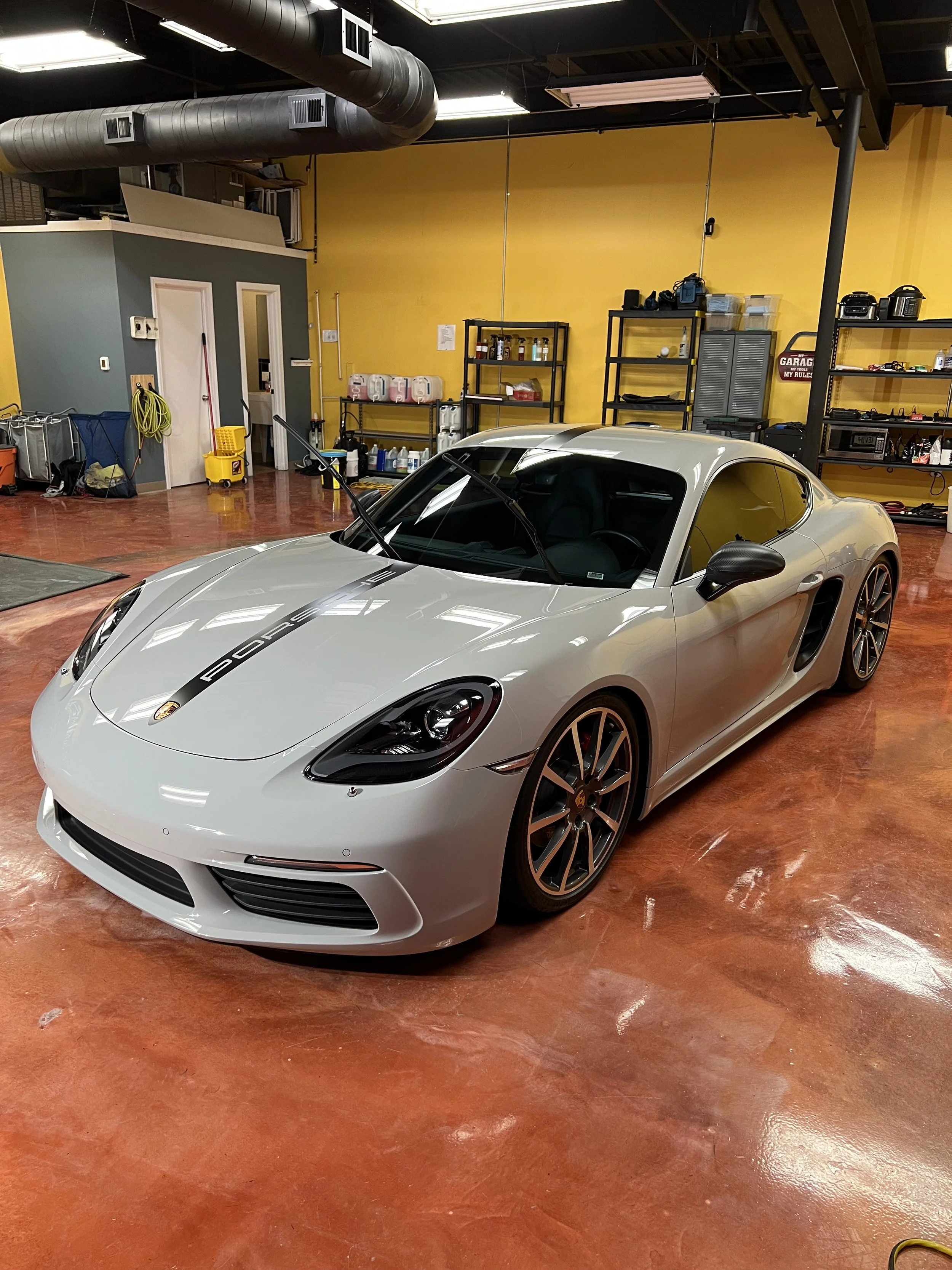 Close up of paint protection film being stretched and applied to a car bumper to prevent rock chips and scratches.