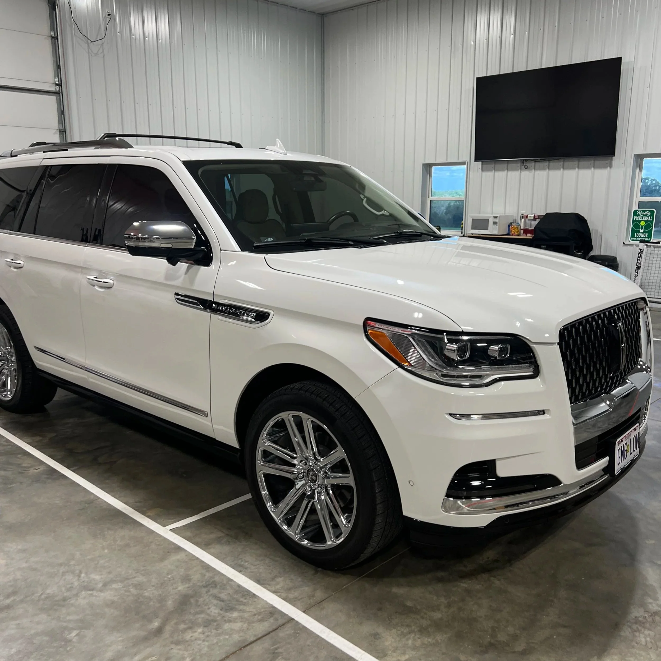 Technician performing paint correction on a car using a dual action polisher to remove swirls and restore gloss at Empire Customs Car Detailing in Kansas City.