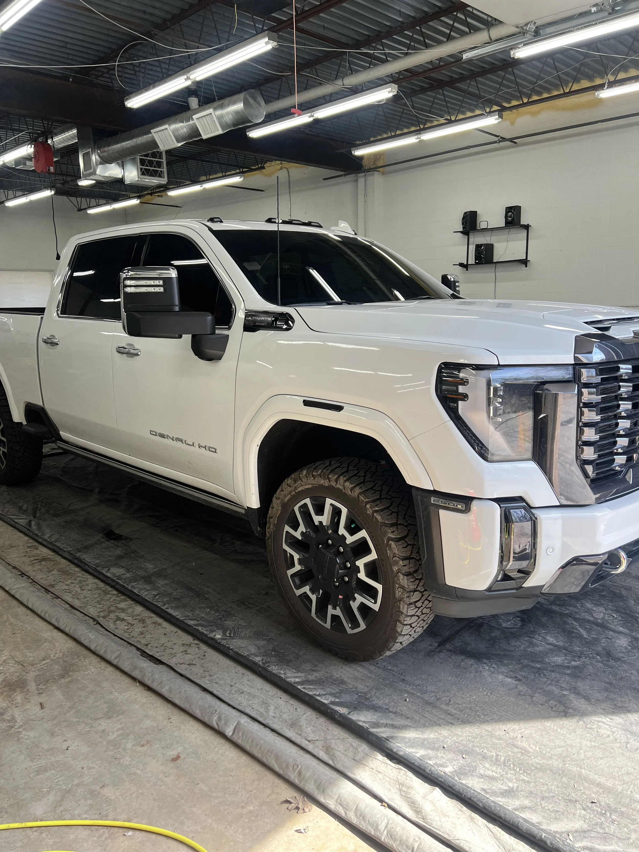 Close up of automotive window tint being heat shaped and smoothed onto a car door glass for a clean seamless finish.