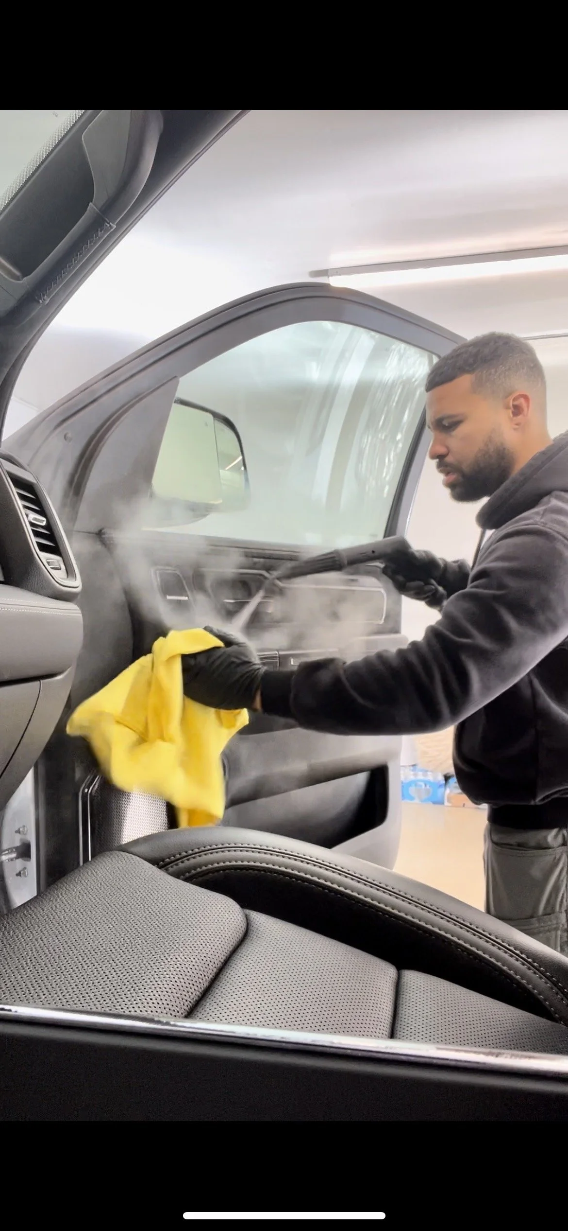 Empire Customs Car Detailing Ceramic Coating & PPF technician performing professional smoke odor removal inside a vehicle in Kansas City using deep interior cleaning and ozone treatment for complete odor elimination.
