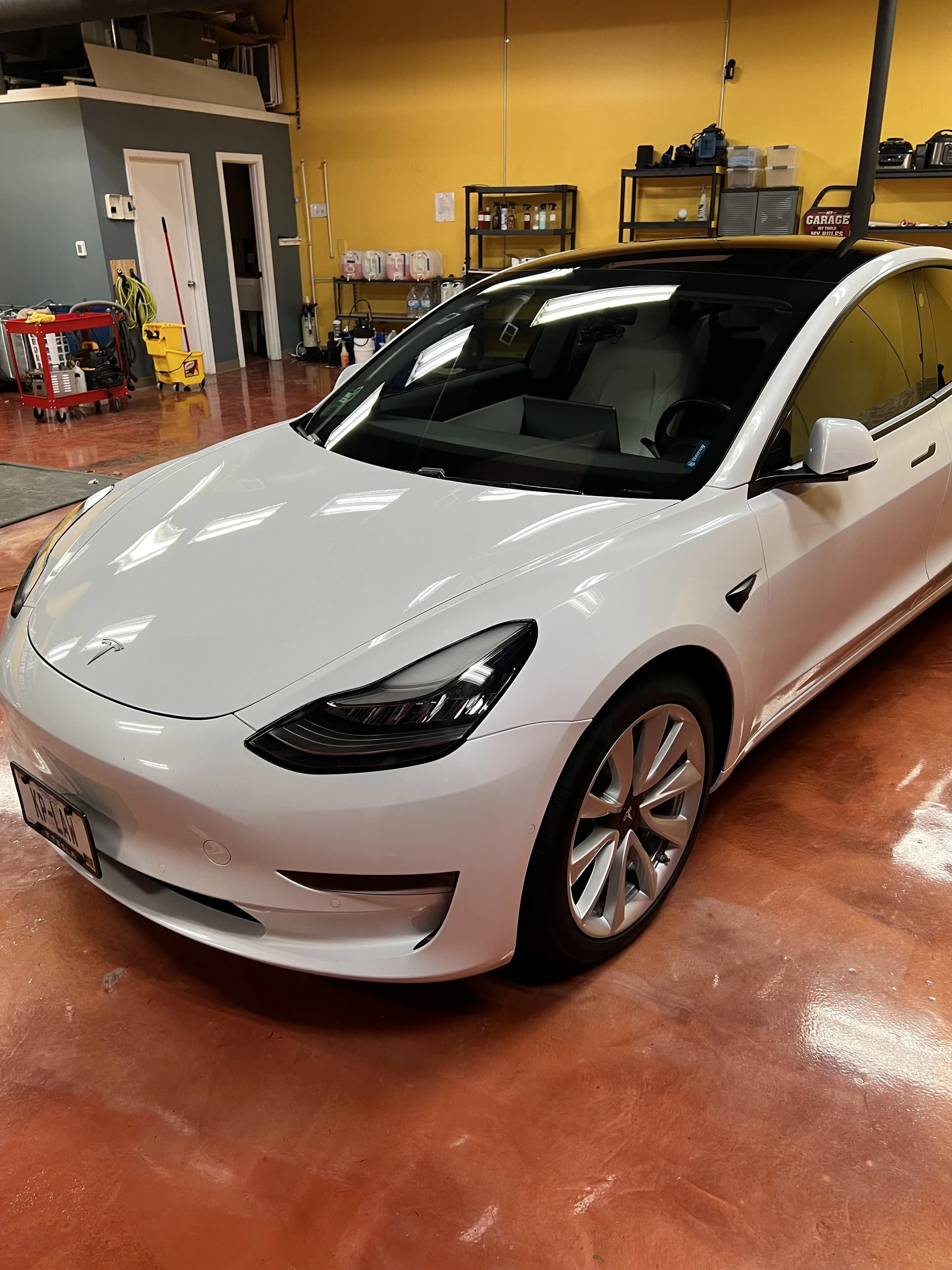 Empire Customs Car Detailing Ceramic Coating & PPF team detailing a Tesla in Kansas City, providing premium interior and exterior cleaning, paint polishing, and ceramic protection.
