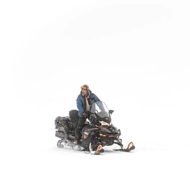 Person riding a snowmobile on snowy terrain