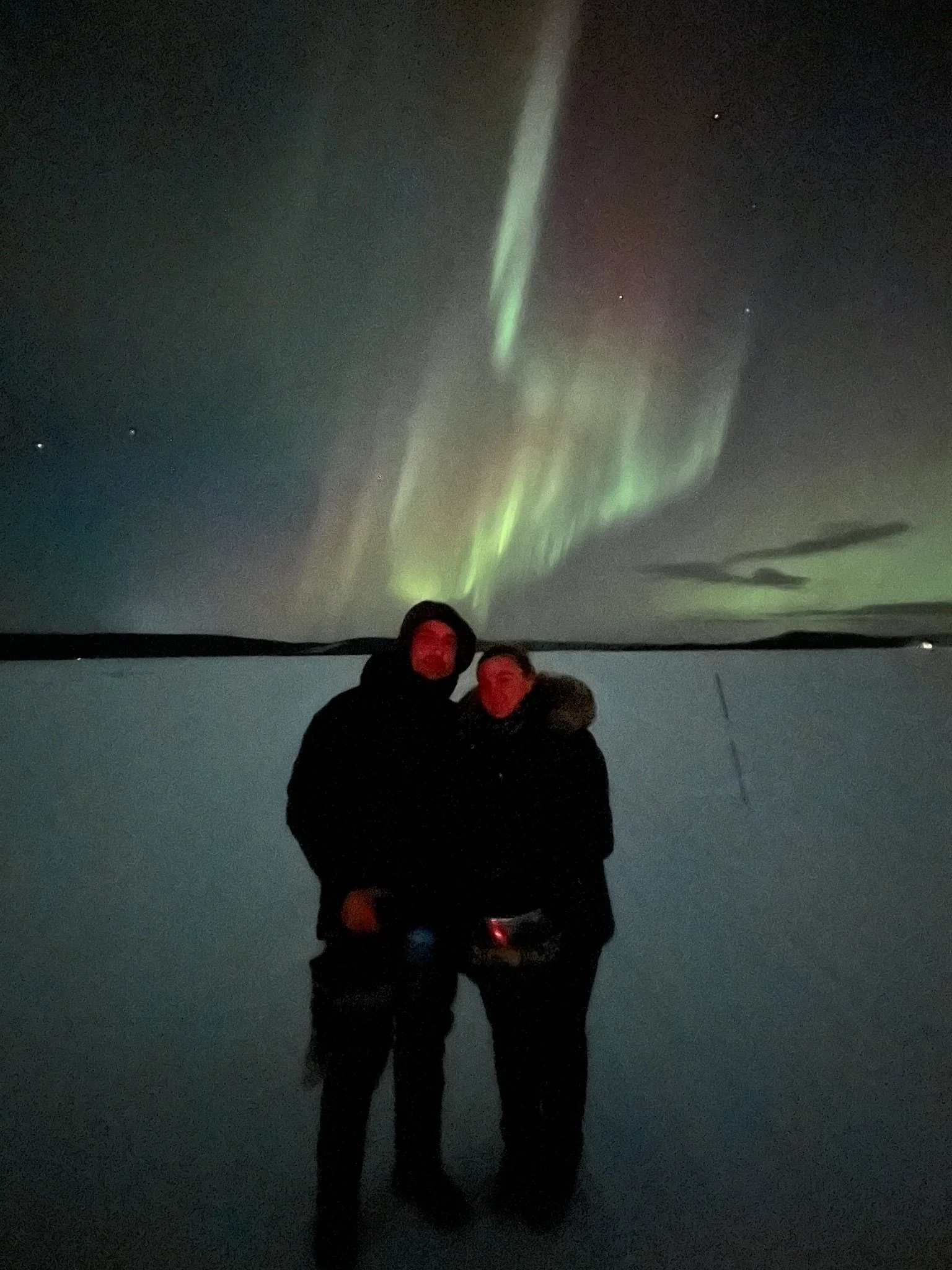 Couple standing under the Northern Lights