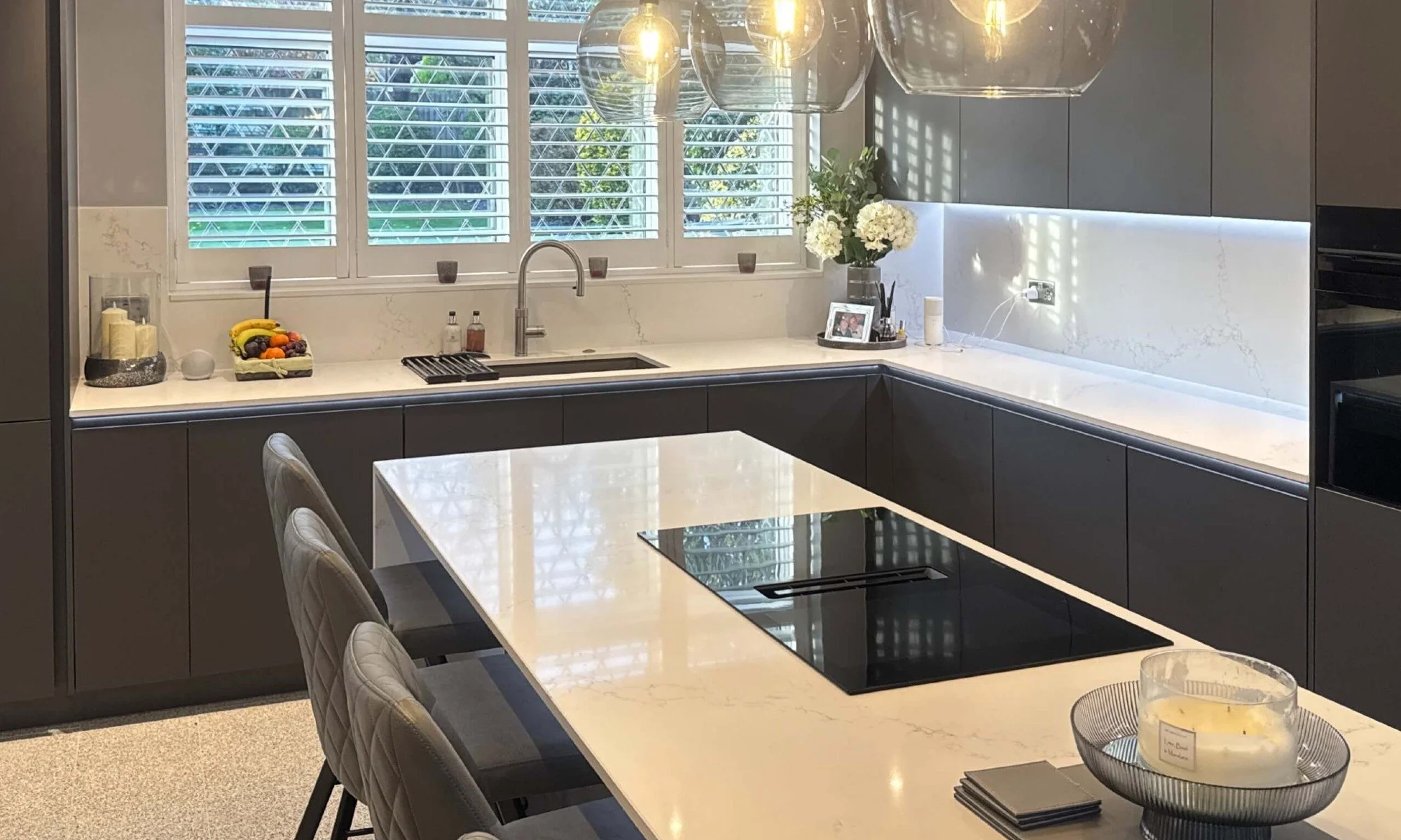 dark grey handleless kitchen with quartz worktop