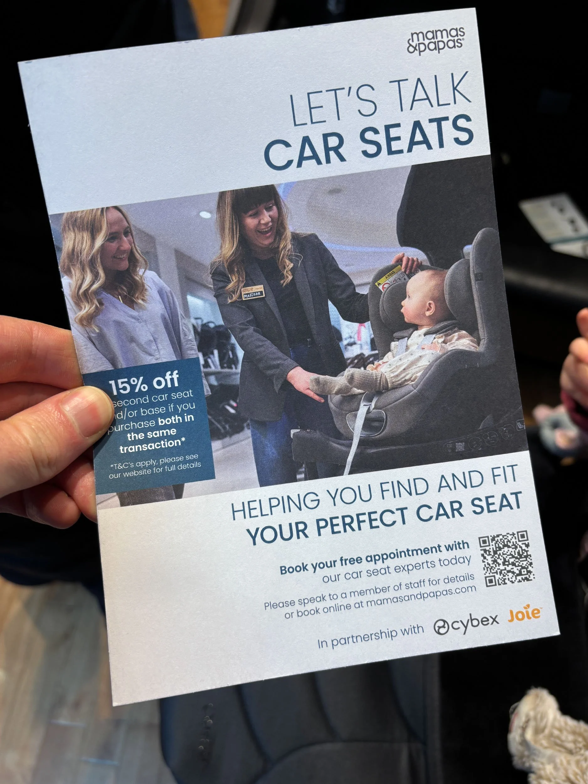 A photo of a leaflet from Mamas & Papas promoting car seat appointments.