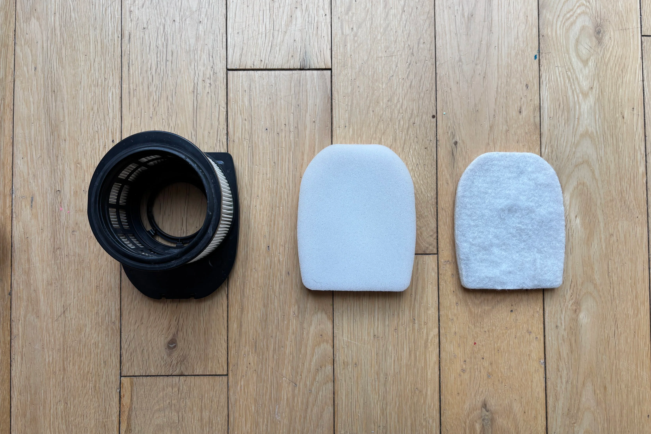 Image of three filters present within a SharkNinja vacuum cleaner. Image is a flat lay on a wooden floor.