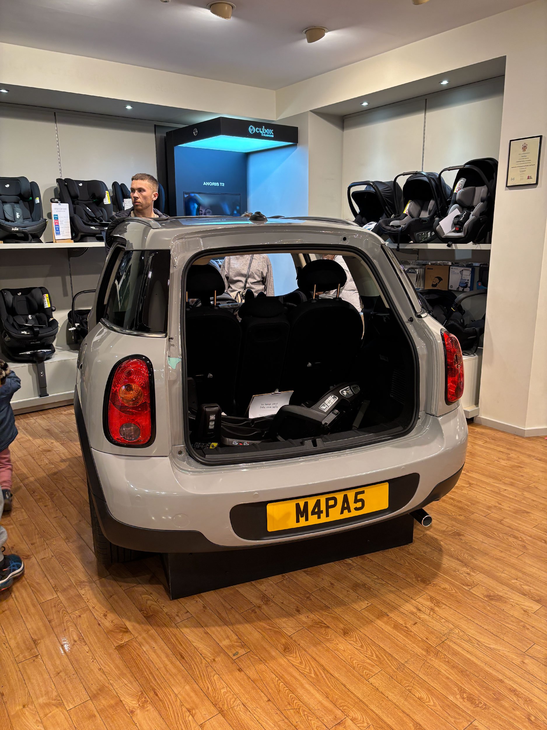 Photo from a Mamas & Papas store featuring half a car used to demonstrate car seats.