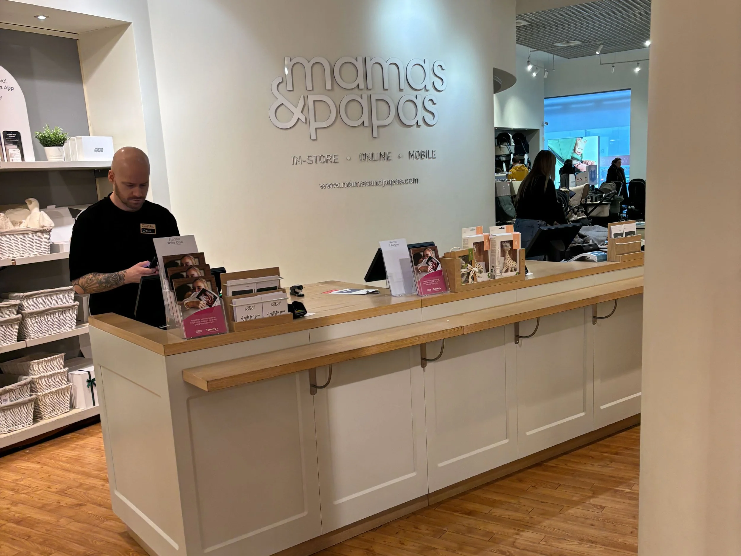 Photo of a member of staff at Mamas & Papas at the till.