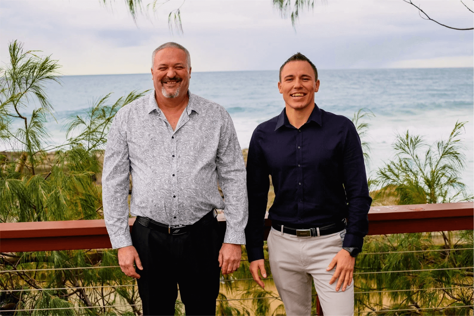 Jacob Little and his father smiling together near the coastline, reflecting on the discussion of the list of compensation payouts